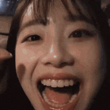 a close up of a woman 's face with her mouth wide open