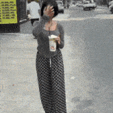 a woman covering her face with her hand while holding a cup with a straw