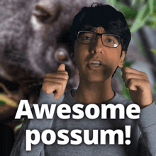 a man wearing glasses giving a thumbs up with the words awesome possum behind him