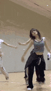 a woman is dancing on a wooden floor in a room