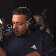 a man wearing a pair of headphones covering his face with his hands