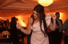 a woman in a white dress is dancing in a crowded room .
