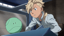 a boy in a white shirt looks at a green ball