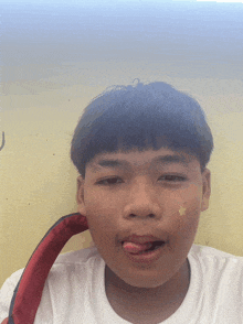 a young boy with his tongue out and a yellow star on his face