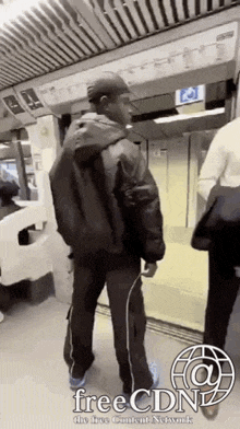 a man in a hat is standing on a train .