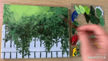 a person is painting a picture of trees on a canvas with the words made in animotica below it