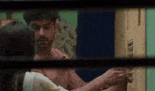 a man and a woman are standing next to each other in front of a door and looking at each other .