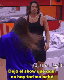 a man in a black tank top is standing next to a woman in a blue sweater with the caption deja el show
