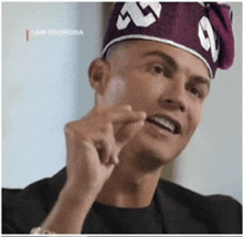 a man wearing a purple hat with the letter g on it .