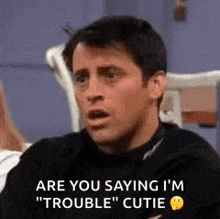 a man is sitting at a table and saying `` are you saying i 'm " trouble '' cutie .