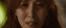 a close up of a woman 's face with a tear running down her cheek .