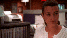 a woman in a white shirt is looking at something