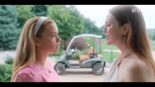 two women are standing next to each other and looking at each other .
