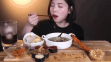 a woman is sitting at a table eating a bowl of soup