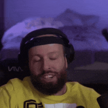 a man wearing headphones and a yellow shirt that says via