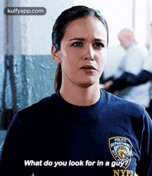 a woman is wearing a police department t-shirt and asking what do you look for in a guy .