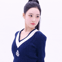 a woman wearing a blue and white sweater with an anchor on the v-neck