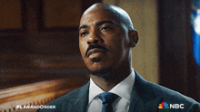 a man in a suit and tie with the nbc logo on the bottom