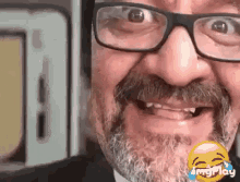 a man with glasses and a beard is making a funny face ..