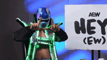 a wrestler is standing in front of a sign that says hey