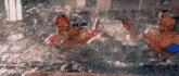 a man and a little girl are swimming in a pool .