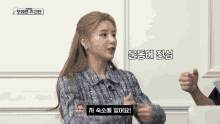 a woman in a blue sweater is talking to someone in a foreign language