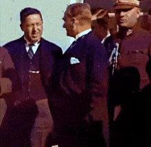 a group of men in suits and hats are standing next to each other and talking