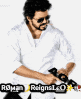 a man wearing sunglasses and a white shirt is holding a gun with roman reigns leo written on it