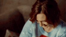 a woman wearing a blue sweater with the letters hhw on it