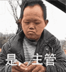 a man in a jacket is holding a piece of paper in his hand and making a funny face .