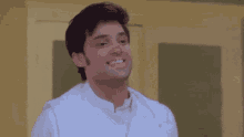 a man in a white shirt is smiling and looking up