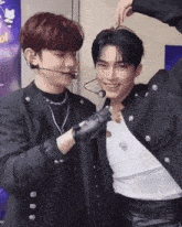 two young men are posing for a picture and one is wearing a microphone