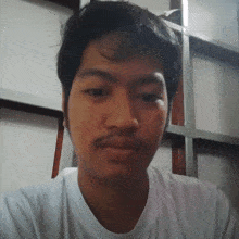 a man with a mustache is wearing a white t-shirt