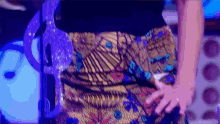 a woman is standing in front of a microphone wearing a colorful skirt .