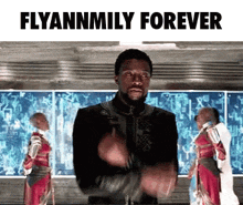 a man in a black jacket is standing in front of a screen that says flyannmily forever