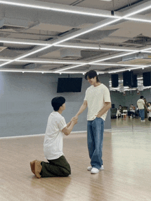 two men are kneeling down in a room holding hands