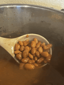a bowl of baked beans with a white spoon in it