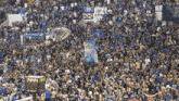 a crowd of people in a stadium with a scoreboard that says 14:44