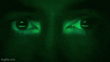 a close up of a person 's face with a green background .