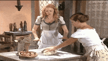 a bag of flour sits on a table next to two women preparing food
