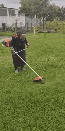 an elderly woman is using a lawn mower in a yard