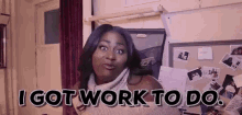 a woman is standing in front of a bulletin board and saying `` i got work to do . ''