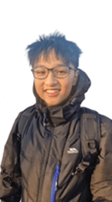 a young man wearing glasses and a black jacket with a backpack is smiling .