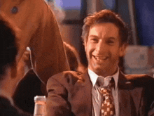 a man in a suit and tie is laughing
