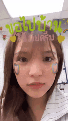 a girl with hearts painted on her face and the word ' ao ' on her forehead
