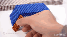 a person is playing with a stack of magnetic beads made by magnetic man