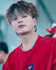 a close up of a person wearing a red fila t-shirt