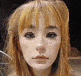 a close up of a woman 's face with red hair