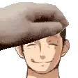 a hand is putting a hat on a man 's head and smiling .