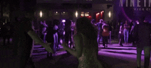 a group of people are dancing in front of a sign that says nine in